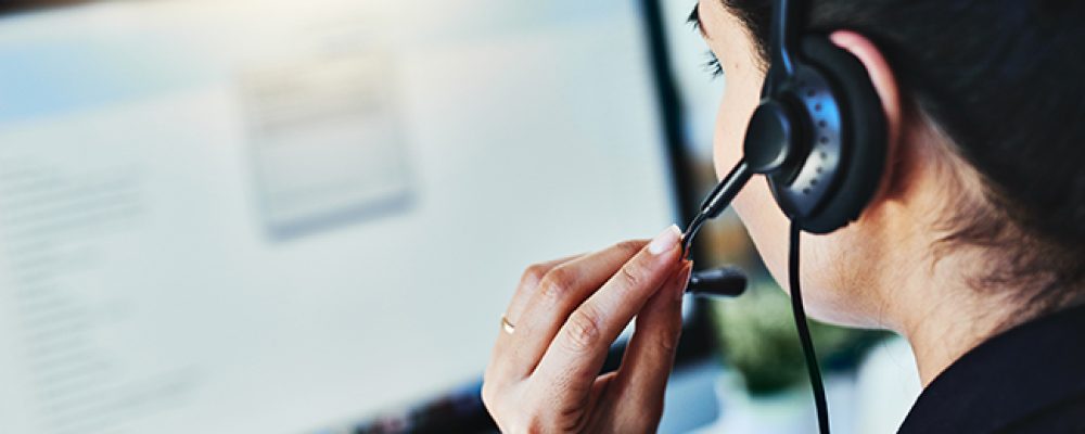 Achteruitkijkopname van een jonge vrouw die in een callcenter werkt